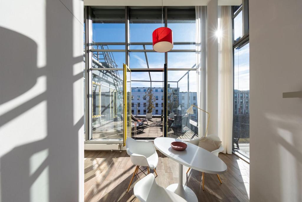 a room with a table and chairs and a large window at Brera Serviced Apartments Munich West in Munich