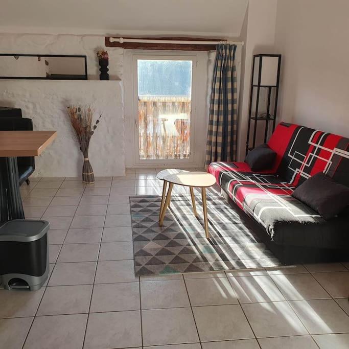 un salon avec un canapé et une table dans l'établissement STUDIO NID COSY avec piscine, à Bonnemain