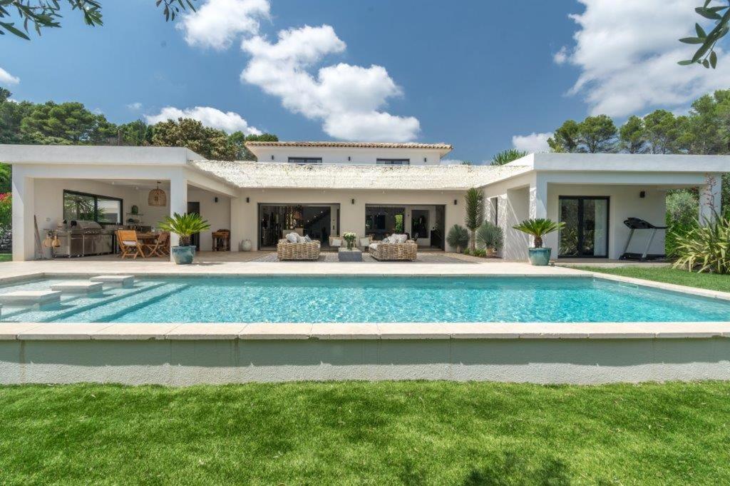 a villa with a swimming pool in front of a house at VAR ZENITUDE in Lorgues