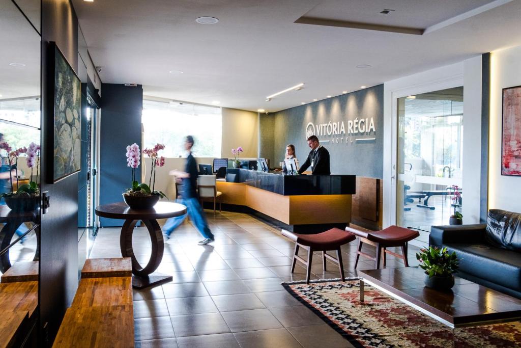 a lobby of a restaurant with people in the counter at Vitoria Regia Hotel Bauru in Bauru