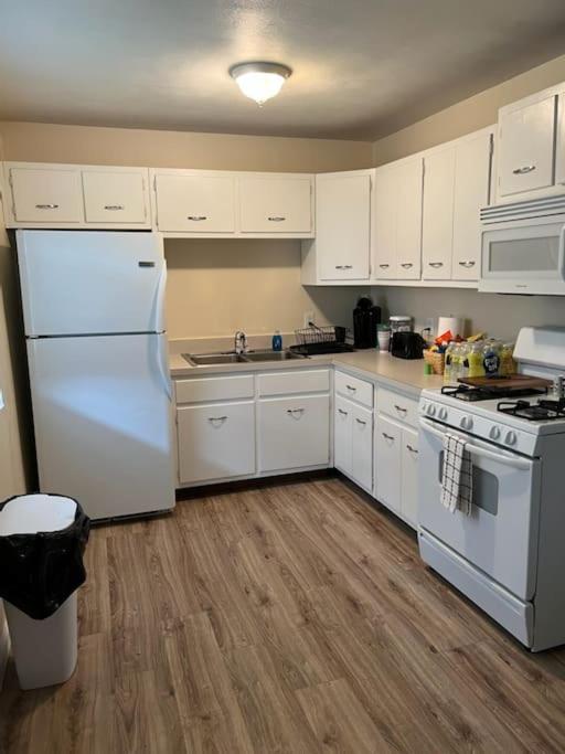 een keuken met witte kasten en een witte koelkast bij Minimalist Mansion in Shiloh