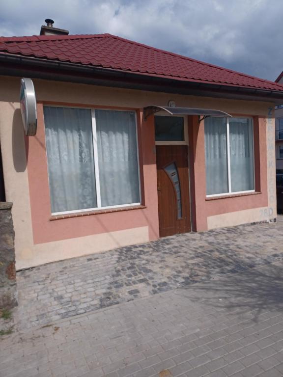una pequeña casa con techo rojo en Fajne Mieszkanko z klimą, en Gołdap