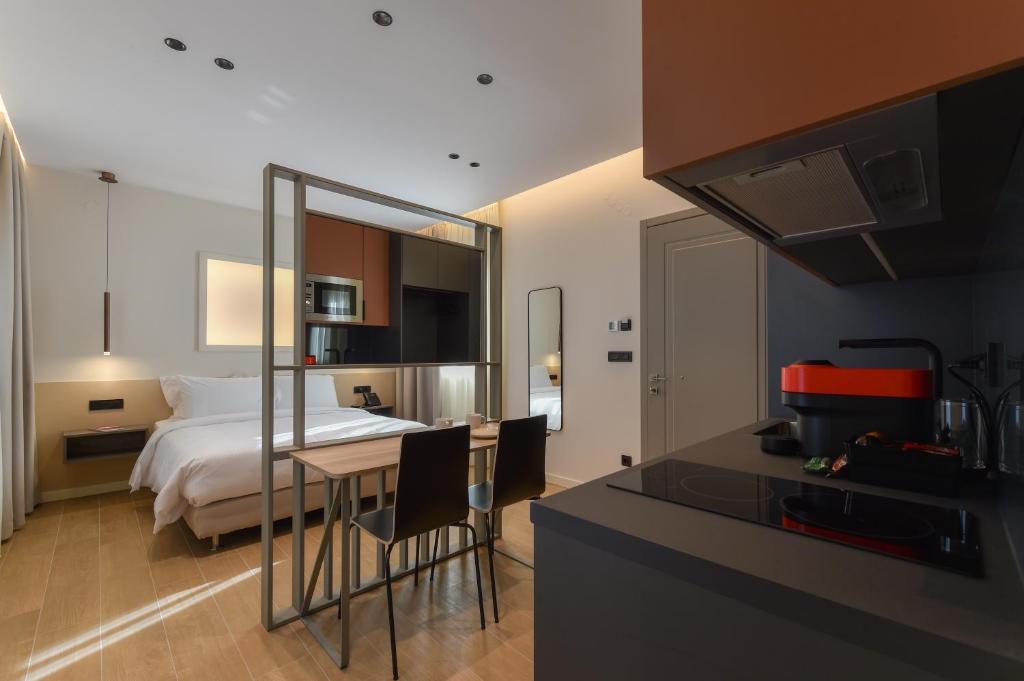 1 dormitorio con 1 cama y cocina con mesa en Zalo Urban Living Spaces, en Ioannina