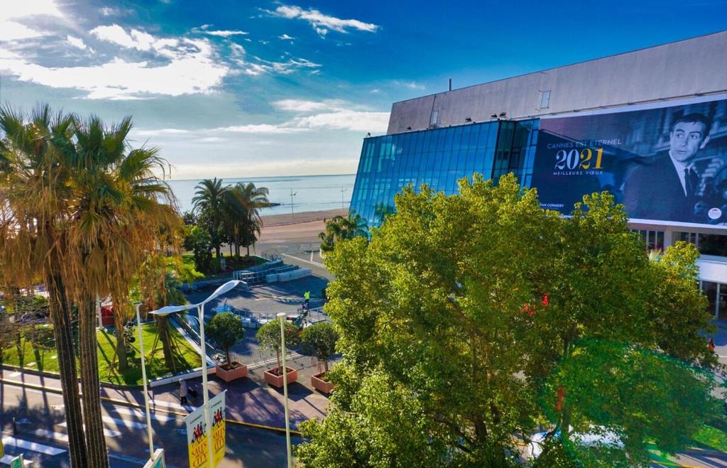 un bâtiment avec un panneau d'affichage à côté d'une plage dans l'établissement Ref LEM4 - Palmes d'Or Properties, à Cannes