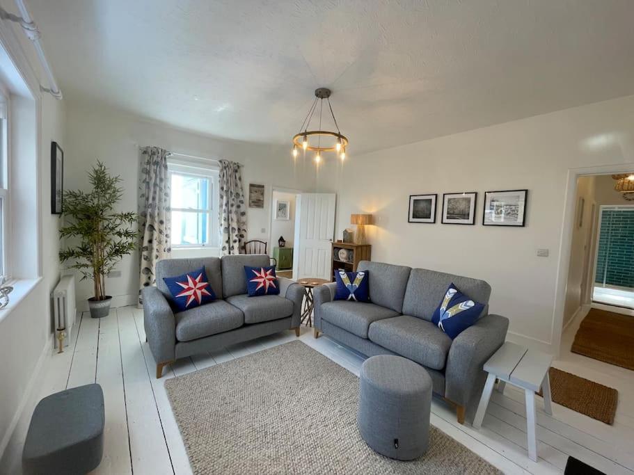 a living room with two couches and a table at Top Deck - Fresh, stylish seaside apartment in Ventnor