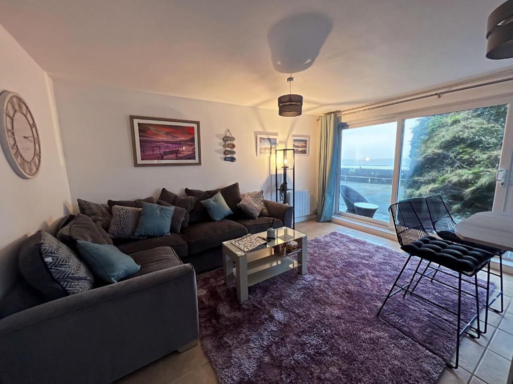 sala de estar con sofá y mesa en Beach Court Ground Floor - Cosy Apartment with Sea Views en Saundersfoot