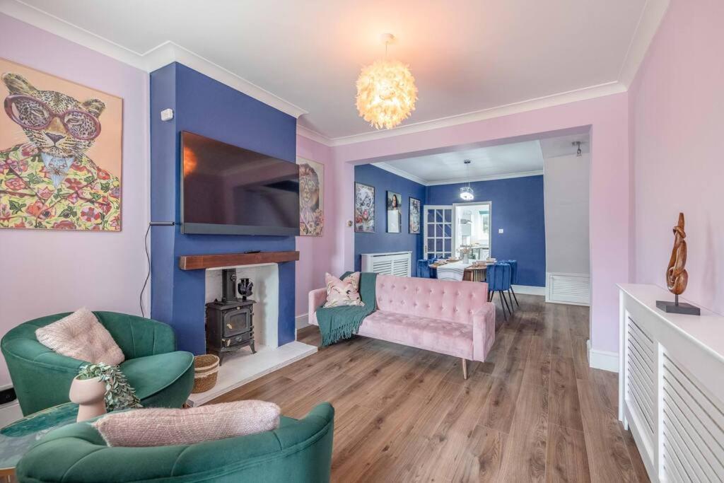 a living room with a pink couch and a fireplace at Victorian Cottage, Close 2 All The Sights, Parking in Windsor