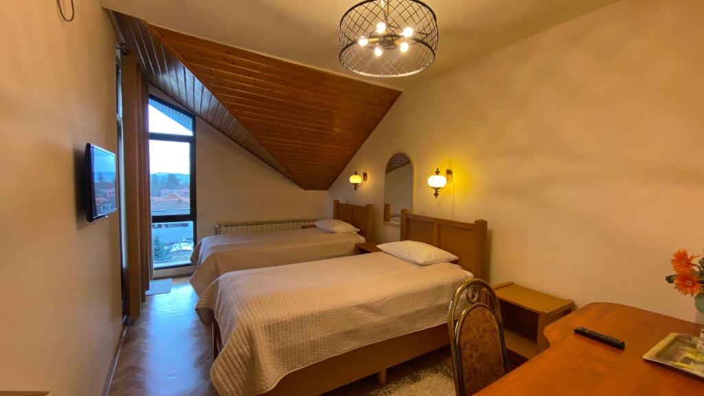 pokój hotelowy z 2 łóżkami i stołem w obiekcie Pensiunea Imperial w mieście Târgu Mureş