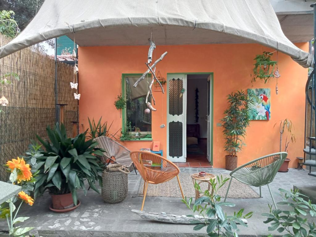 een oranje huis met stoelen en planten ervoor bij Mango House in Milano Marittima