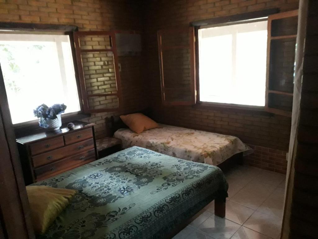 a bedroom with two beds and two windows at Sítio Completo, na estrada de Aldeia Velha, com rio a frente da porteira in Silva Jardim