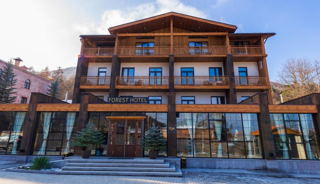 a wooden building with a balcony on top of it at Forest 1961 Boutique Hotel & Restaurant in Vanadzor