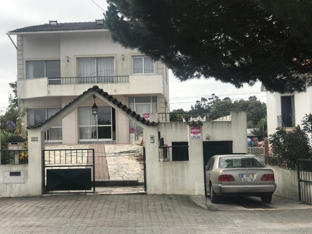 a car parked in front of a white house at Joe's House in Fátima