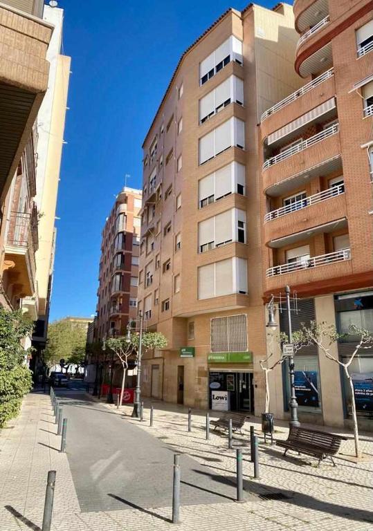 an empty street in front of a tall building at Frente a Puerto Azahar 2 in Grao de Castellón