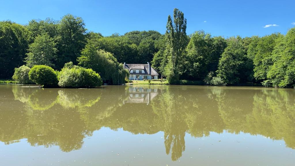 une maison se reflète dans l'eau d'un lac dans l'établissement 
