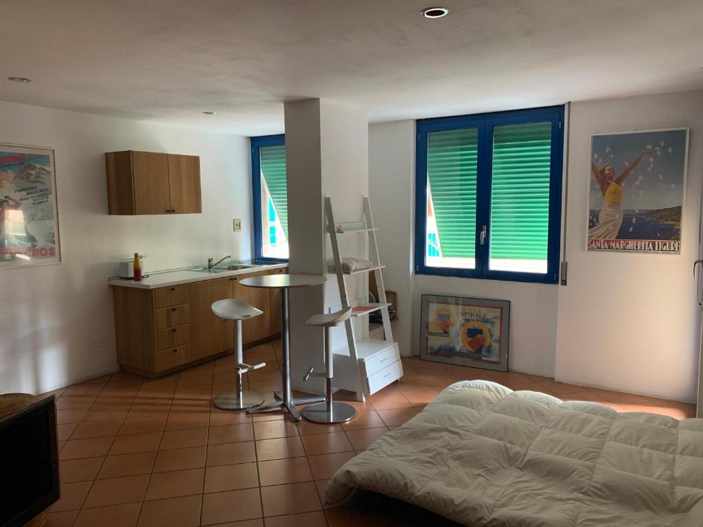sala de estar con cama y cocina con ventanas en Rapallo Minimal House, en Rapallo