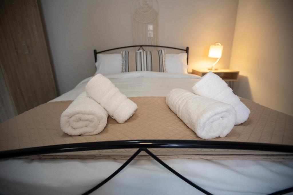 Una cama con dos toallas enrolladas encima. en Syros Moments, en Ermoupoli