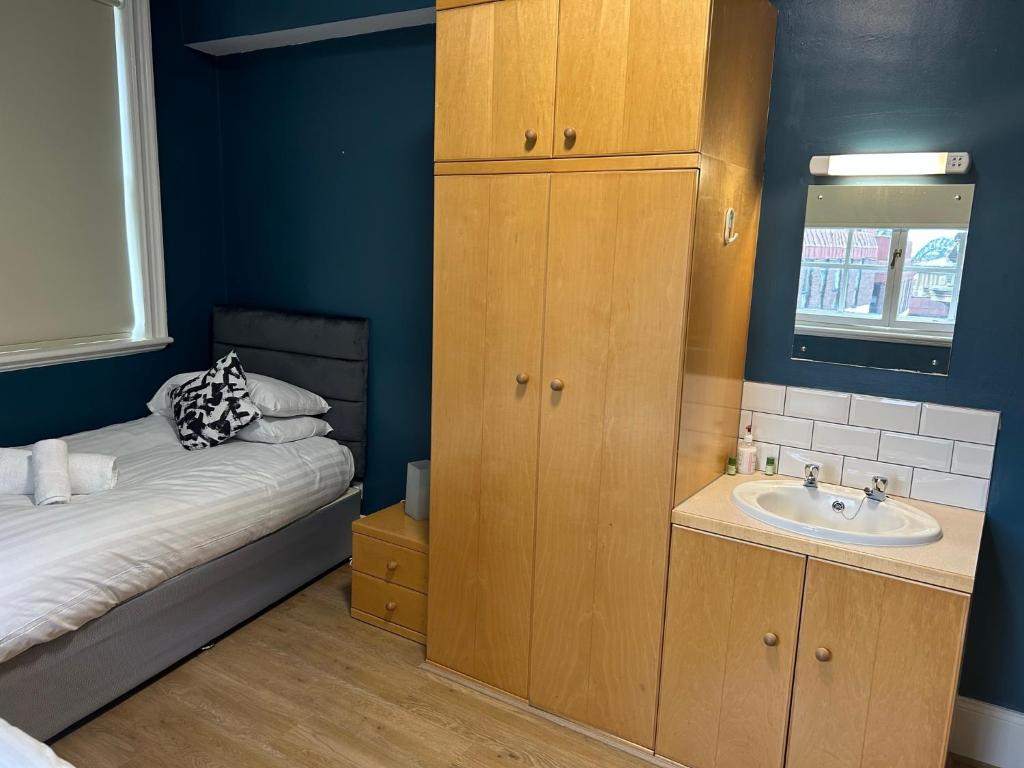 a small bathroom with a sink and a bed at Bigg Market Apartments in Newcastle upon Tyne