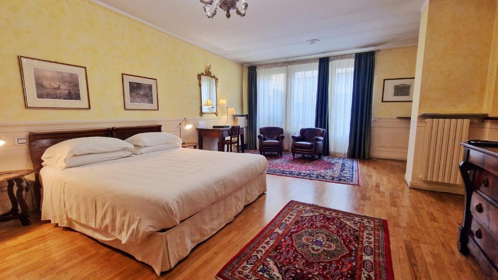 a bedroom with a bed and a table and chairs at Relais Vimercati in Crema