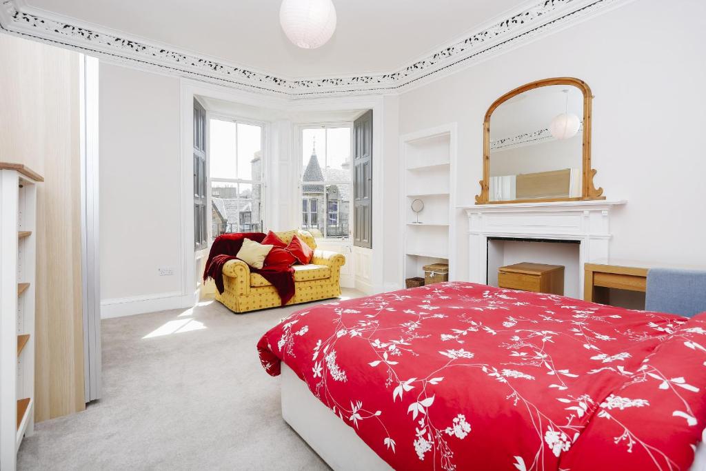 Schlafzimmer mit einem roten Bett und einem Kamin in der Unterkunft Fabulous 5 Double Bedroom Edinburgh Old Town apartment in Edinburgh