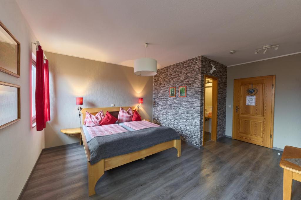sypialnia z łóżkiem i ceglaną ścianą w obiekcie Landhotel Brauner Hirsch w mieście Kammerforst