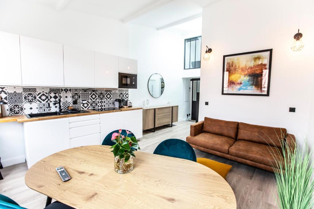 een keuken en een woonkamer met een tafel en een bank bij Magnifique Duplex 2ch / 2 sdb in Marseille