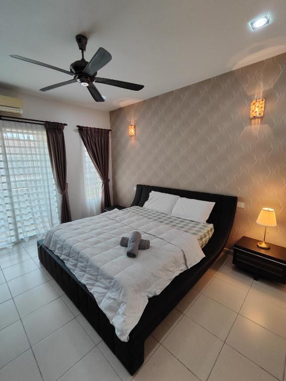 sypialnia z dużym łóżkiem i wentylatorem sufitowym w obiekcie Ipoh Premium Cozy Relax Home w mieście Ipoh