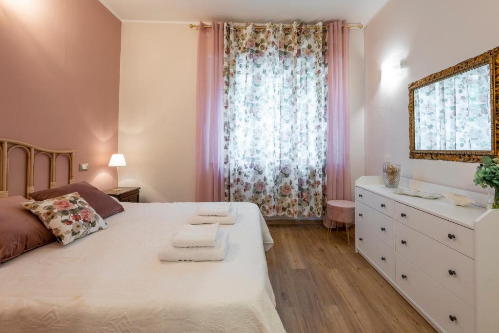 um quarto com uma cama, uma cómoda e uma janela em BnButler - Principe Eugenio - Casa Corsini, un Angolo Retrò em Milão
