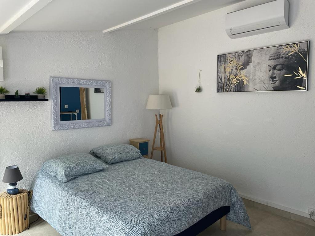 ドラギニャンにあるAu Sabluline chambres d'hôtes gîtesのベッドルーム1室(ベッド1台付)が備わります。壁に絵が飾られています。