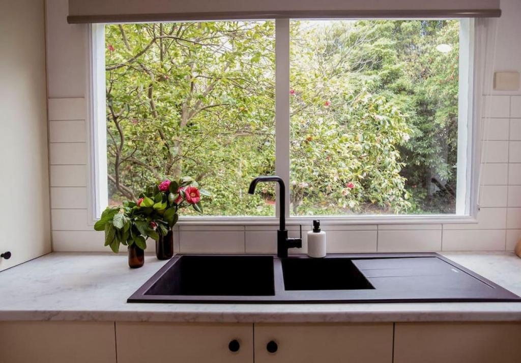 a kitchen with a sink and a window at Very Cool Mid Century, Pet Friendly Urban Oasis in Geelong