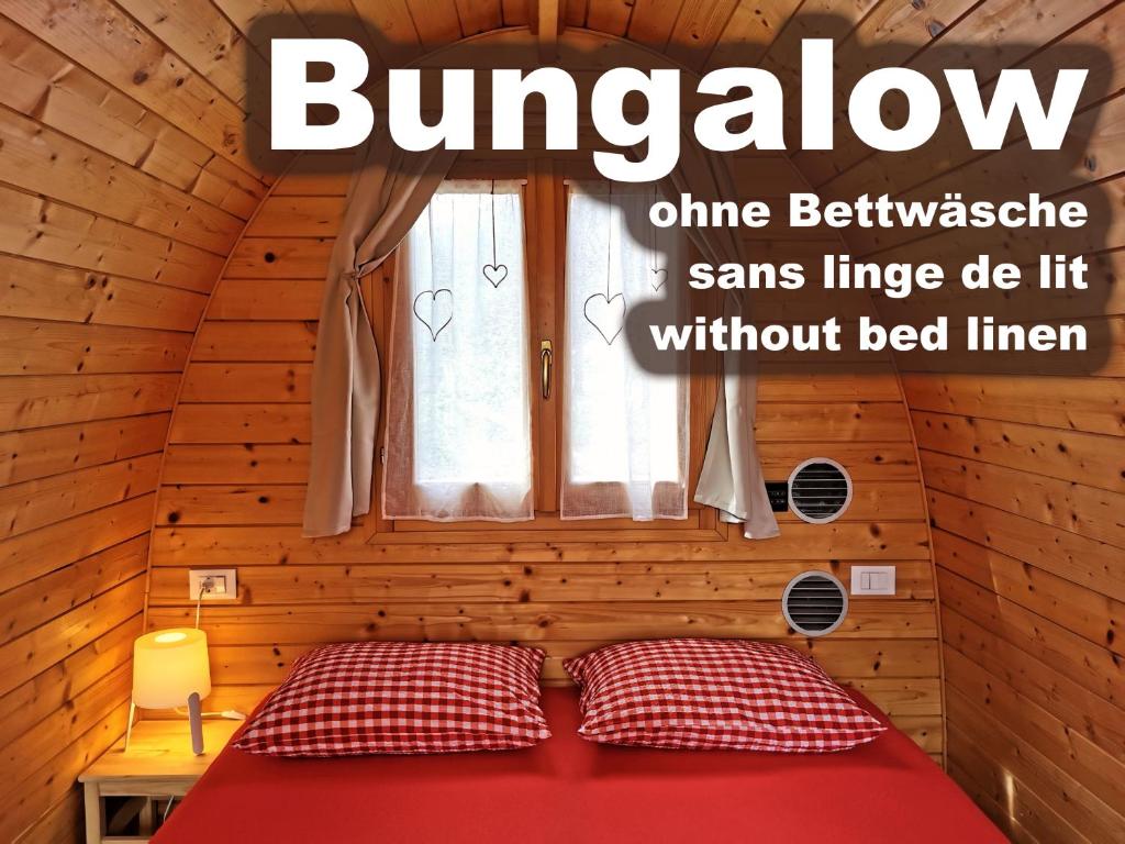 uma cama num quarto de madeira com uma janela em Camping Melezza em Losone