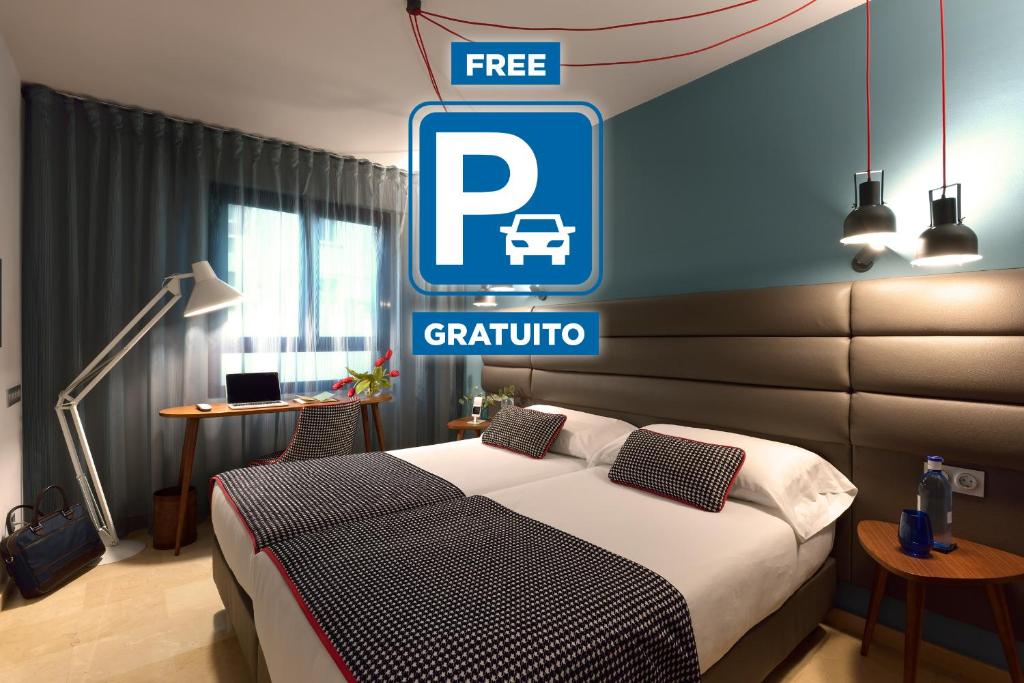 a hotel room with a bed and a free parking sign at Hotel Pamplona Plaza in Pamplona