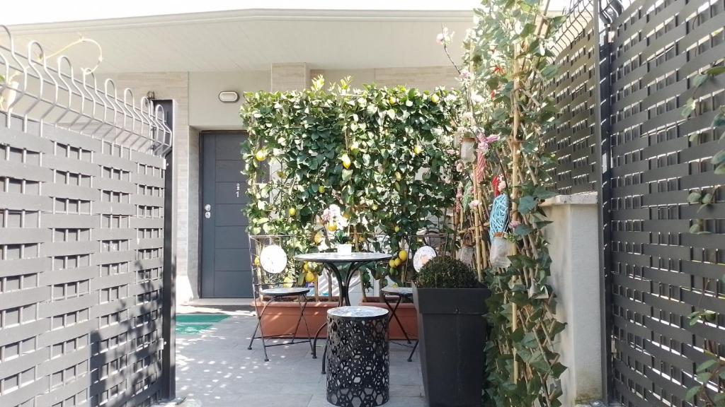 d'une terrasse avec une table et un mur vert. dans l'établissement Tiny Green apartament in Rome - Magliana, à Rome