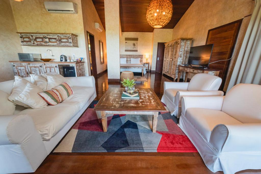 a living room with white couches and a coffee table at Oka Da Mata in Pipa