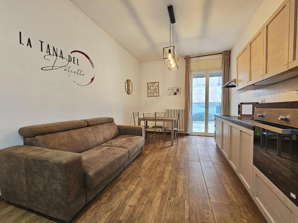 un soggiorno con divano e tavolo di La Tana del Dolcetto, alloggio con terrazzo a Dogliani