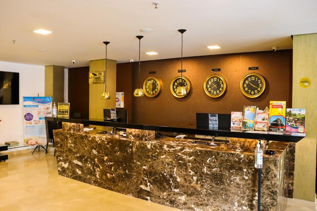 a hotel lobby with clocks on the wall at hotel medellin gold in Medellín