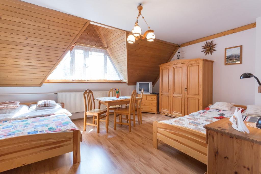 sypialnia z 2 łóżkami, stołem i krzesłami w obiekcie Apartament Dolne Krupowki w Zakopanem