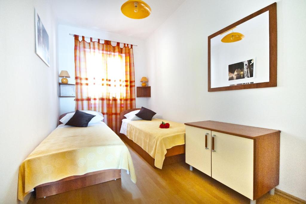 1 dormitorio con 2 camas, armario y ventana en Apartments Superb View, en Dubrovnik