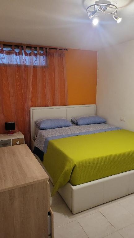 a bedroom with a bed with a yellow blanket at Paraiso S in Villasimius