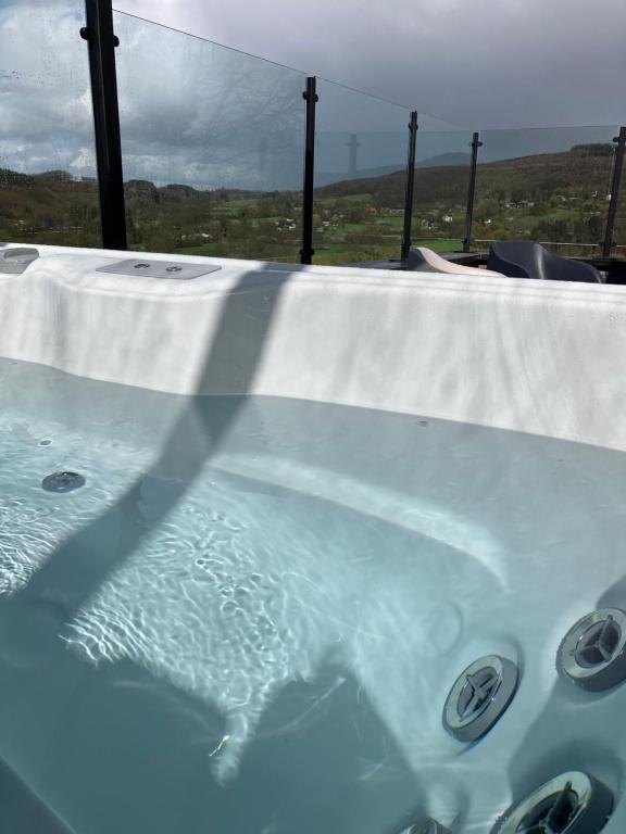 eine Whirlpool-Badewanne mit einem weißen Tischtuch drauf in der Unterkunft Le beau petit bosquet in Hotton