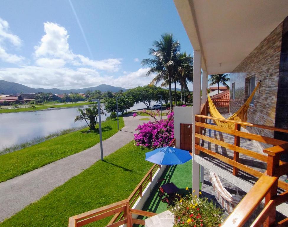 uma casa com uma varanda com vista para um rio em Recanto da Lagoa Flat em Ilha Comprida