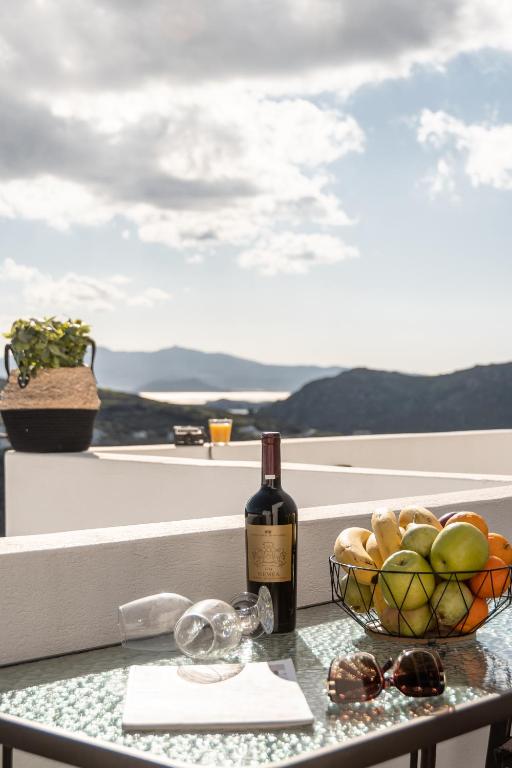 a bottle of wine and a bowl of fruit on a table at Nick & Debbie's Two-Storey Apartment in Mélanes