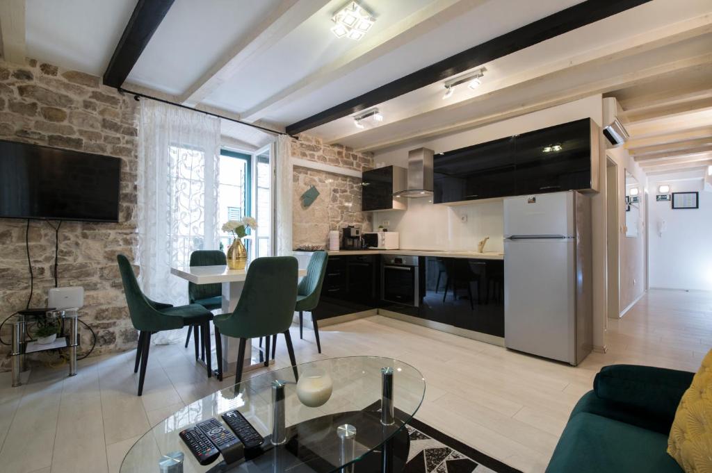 ein Wohnzimmer mit einem Tisch und einer Küche in der Unterkunft Apartment Stone in Split