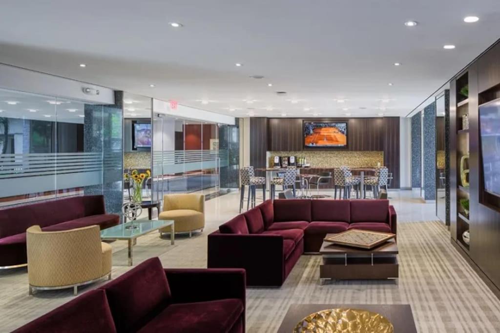 a living room with purple couches and a bar at Privacy and Exclusivity Condo at Crystal City With Gym in Arlington