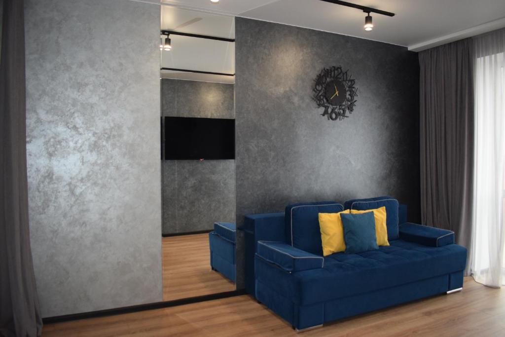 um sofá azul com almofadas amarelas numa sala de estar em Дизайнерські апартаменти в ЖК DreamTown 10б em Lutsʼk
