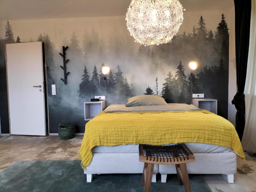a bedroom with a bed with a forest mural on the wall at Ausblick Maisenbach in Bad Liebenzell