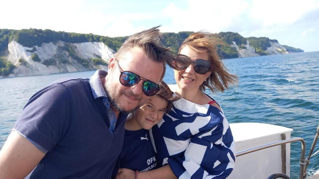 Un uomo e due donne su una barca sull'acqua di Klintholm B & B Bistro a Borre