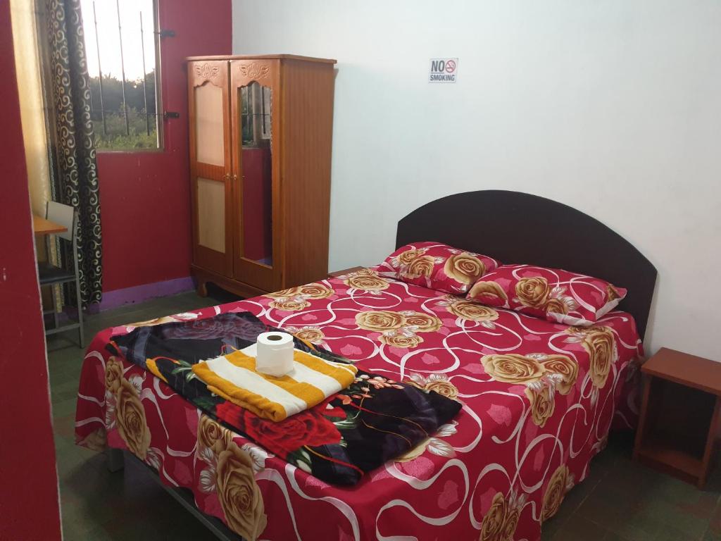 1 dormitorio con 1 cama con manta roja y dorada en Villa Pte Aux Piments en Pamplemousses