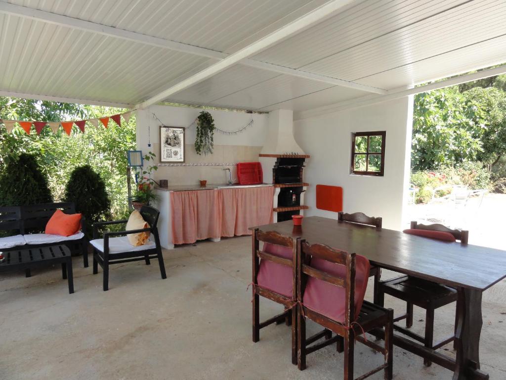 a dining room with a table and a kitchen at Casa do Moleiro in Santiago do Cacém