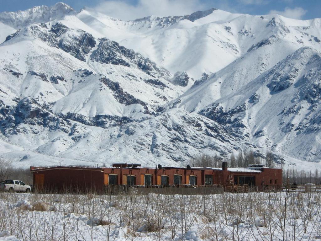 a train in front of a snow covered mountain at Hotel boutique Pukarainca in Uspallata