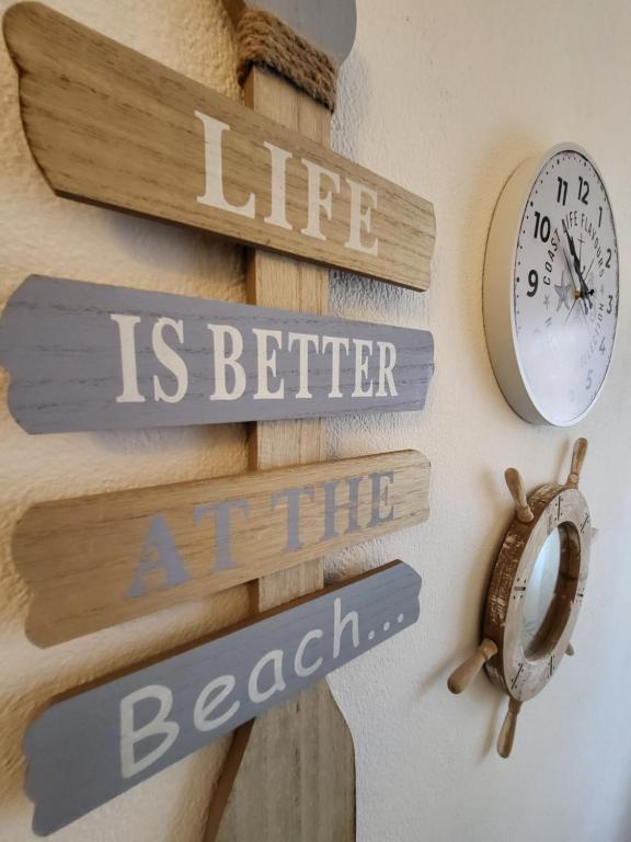 un reloj y algunas señales en una pared en ApartmaniinPrimosten, en Primošten